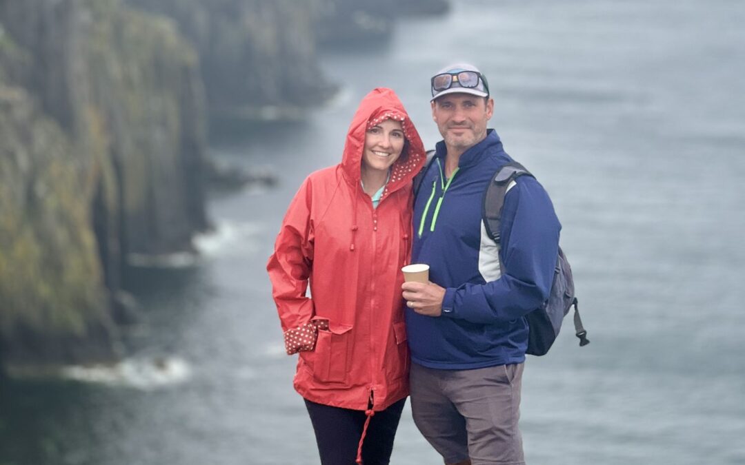 couple on cliffs with Neist Point Lighthouse Isle of Skye