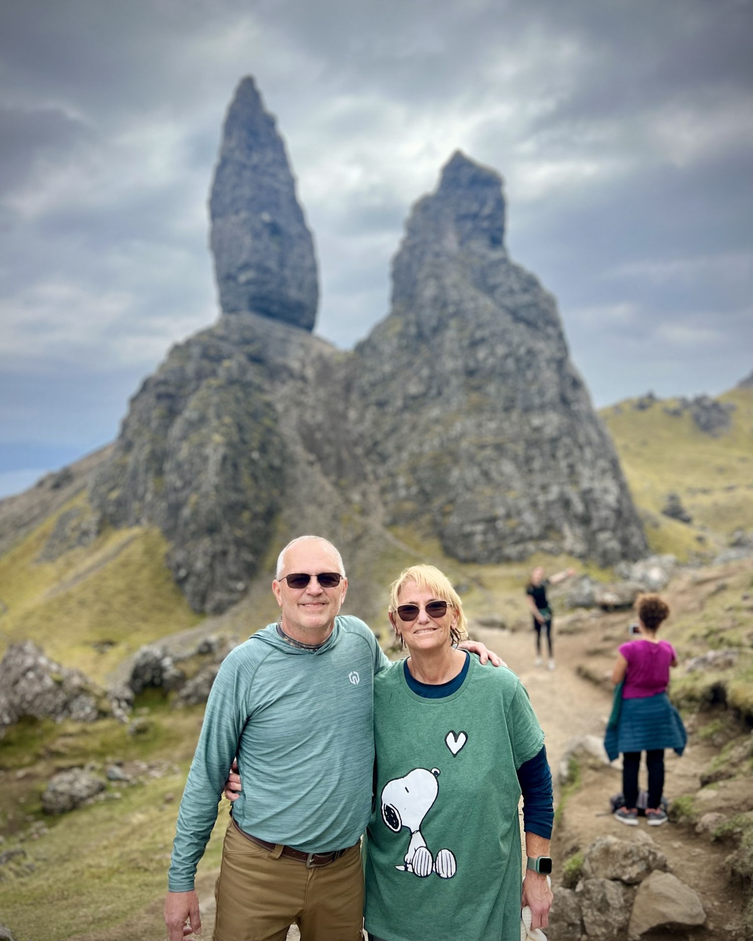 couple standing in front of old man of storr rock formation