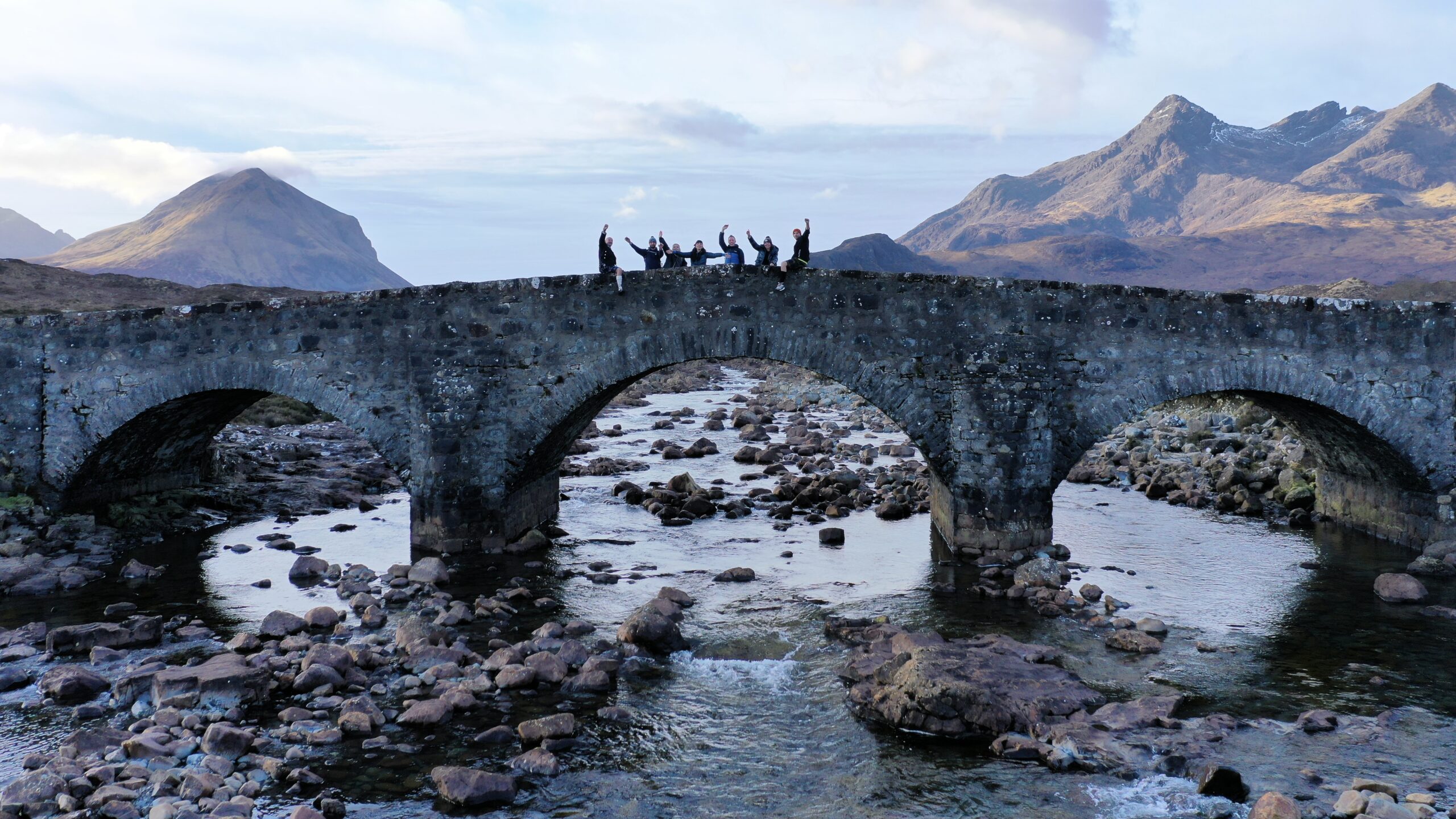 Corporate group photo on Sligachan Bridge with the Cuillin mountains in the background, Isle of Skye